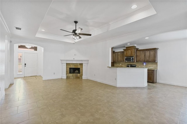 2633 Date Palm Dr, Corpus Christi, TX 78418 - unfurnished living room with a tray ceiling, a ceiling fan, arched walkways, recessed lighting, and baseboards