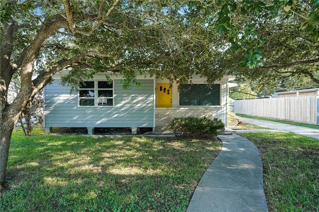 view of front facade featuring fence and a front lawn