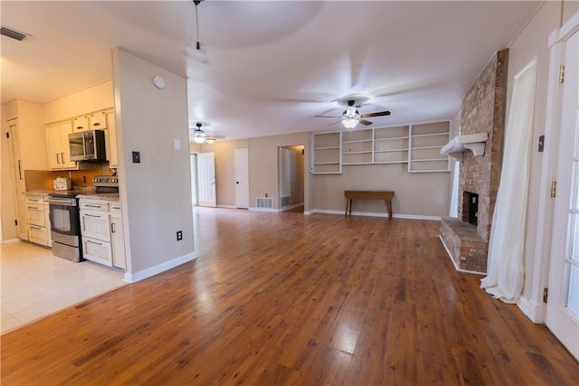 3814 Whitney Dr, Corpus Christi, TX 78410 - unfurnished living room featuring ceiling fan, light wood-style floors, and a fireplace