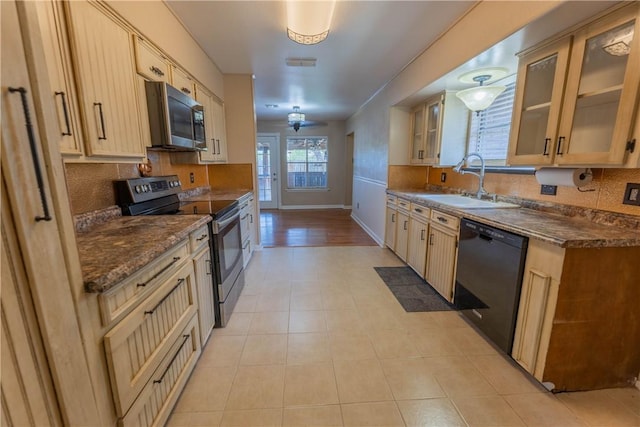 3814 Whitney Dr, Corpus Christi, TX 78410 - kitchen with appliances with stainless steel finishes, decorative backsplash, glass insert cabinets, light tile patterned floors, and dark stone counters