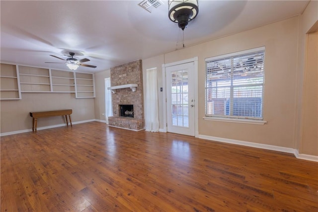 3814 Whitney Dr, Corpus Christi, TX 78410 - unfurnished living room featuring ceiling fan, wood finished floors, a stone fireplace, and built in features