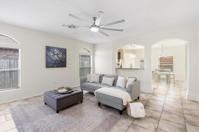 8129 Resplandor St, Corpus Christi, TX 78414 - living area with arched walkways, a ceiling fan, light tile patterned floors, and a chandelier