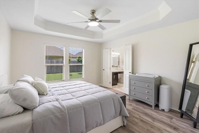 8129 Resplandor St, Corpus Christi, TX 78414 - bedroom featuring a tray ceiling, light wood-type flooring, crown molding, a ceiling fan, and ensuite bathroom