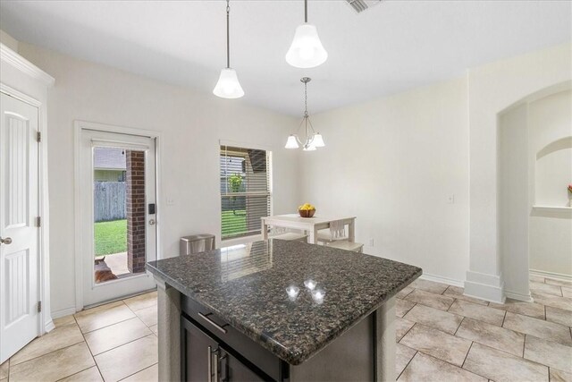 8129 Resplandor St, Corpus Christi, TX 78414 - kitchen with decorative light fixtures, dark stone counters, baseboards, a center island, and a chandelier