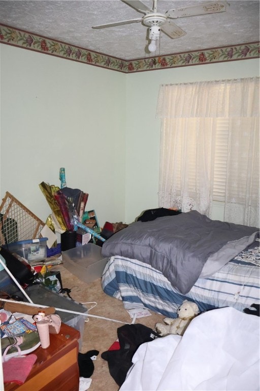 bedroom featuring ceiling fan, a textured ceiling, and carpet flooring