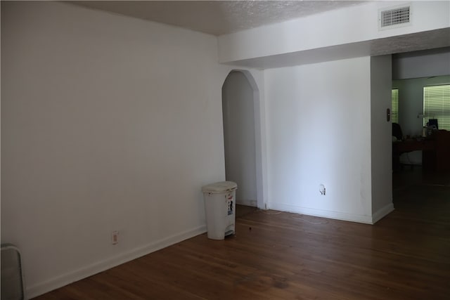 empty room featuring dark wood-type flooring and a textured ceiling