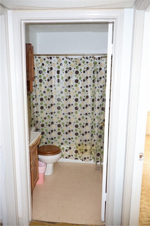 bathroom featuring toilet, vanity, and a shower with shower curtain