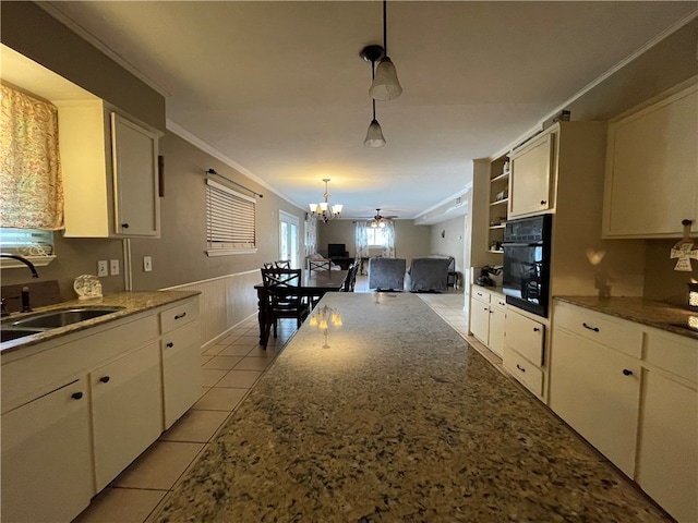 kitchen featuring sink, black oven, ceiling fan, crown molding, and pendant lighting