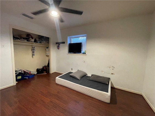 bedroom featuring ceiling fan, a closet, and dark hardwood / wood-style flooring