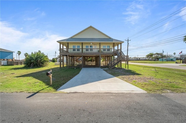 coastal home with a carport, a porch, and a front lawn