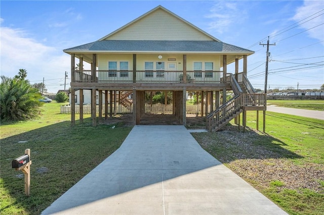 coastal inspired home featuring a carport, covered porch, and a front lawn