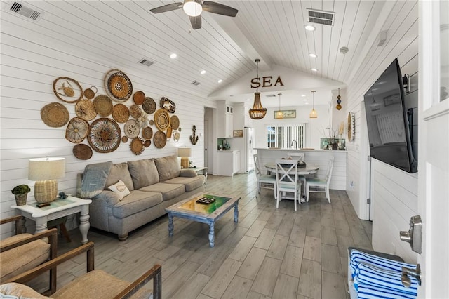 living room with lofted ceiling, wood ceiling, ceiling fan, and wood walls