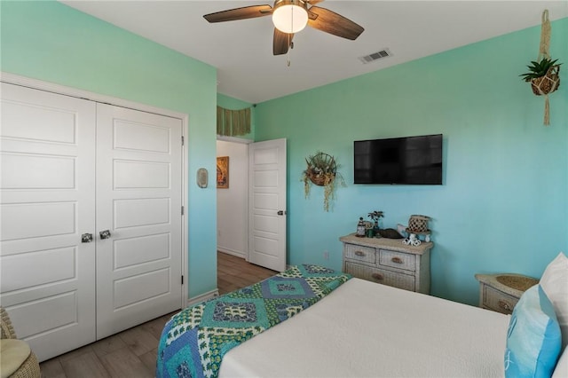 bedroom featuring ceiling fan, hardwood / wood-style floors, and a closet