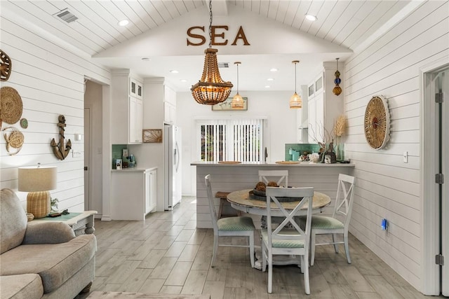 dining area featuring wooden ceiling, lofted ceiling, and wood walls