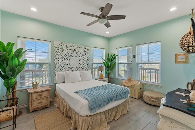 bedroom featuring multiple windows, light wood-type flooring, and ceiling fan