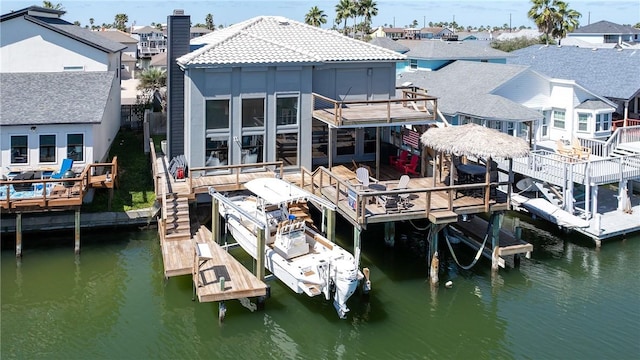 view of dock featuring boat lift, a residential view, and a water view