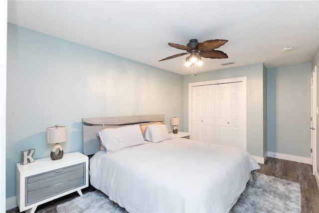 bedroom featuring visible vents, baseboards, wood finished floors, a closet, and a ceiling fan