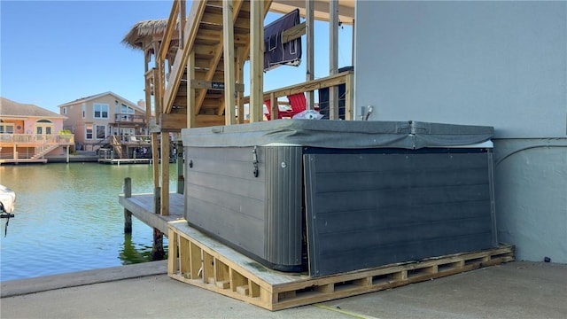 view of dock with a water view and a hot tub