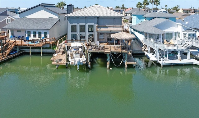 dock area with boat lift, a residential view, and a water view