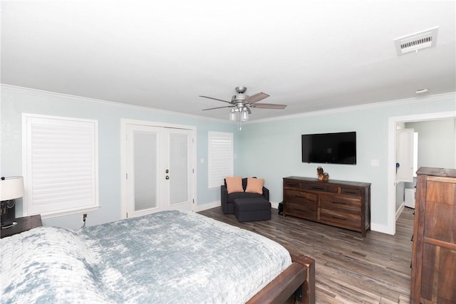 bedroom with visible vents, baseboards, ornamental molding, wood finished floors, and a ceiling fan