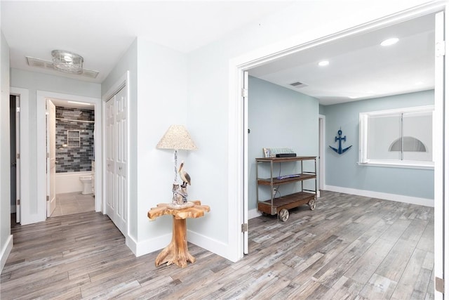 corridor with visible vents, recessed lighting, baseboards, and wood finished floors