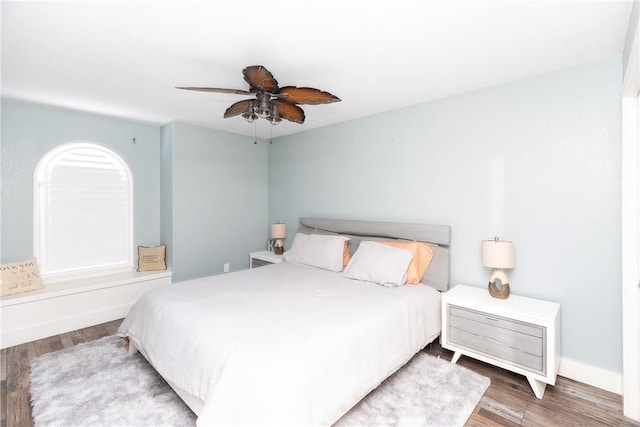 bedroom featuring ceiling fan, baseboards, and wood finished floors