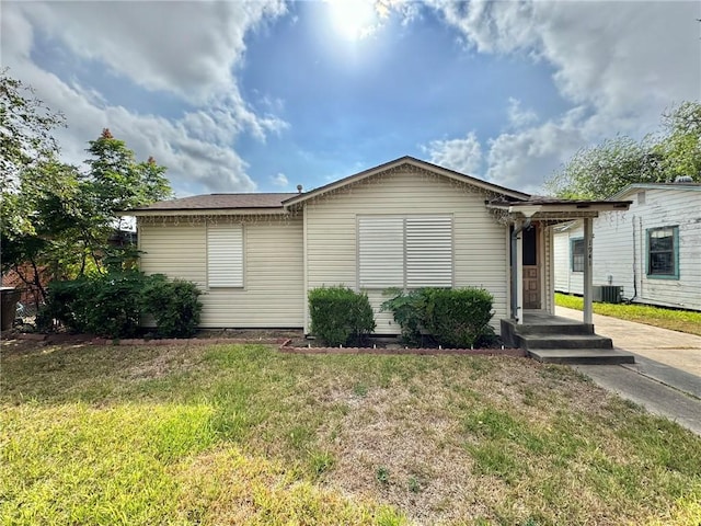 view of front of property featuring central AC unit and a front lawn