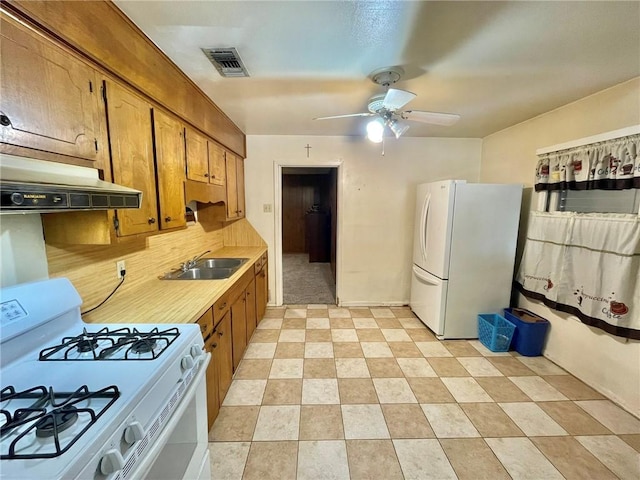 kitchen with white appliances, ceiling fan, sink, and decorative backsplash