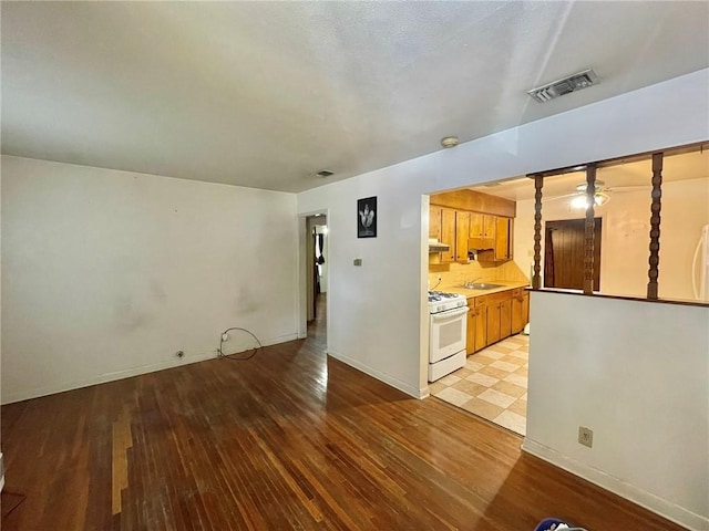 unfurnished living room with sink and light hardwood / wood-style flooring