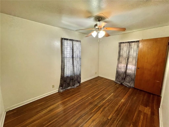 empty room featuring ceiling fan and dark wood-type flooring