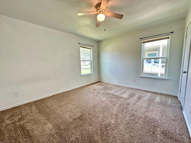 carpeted spare room featuring ceiling fan