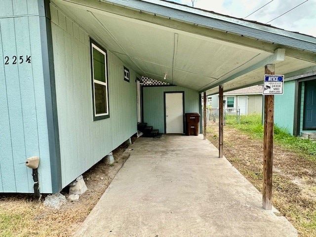 view of patio / terrace with a carport and a storage shed