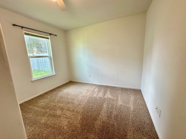 carpeted spare room featuring ceiling fan