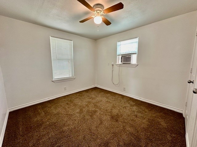 carpeted empty room featuring cooling unit, a textured ceiling, and ceiling fan