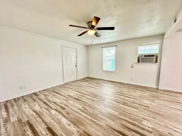 spare room featuring ceiling fan, cooling unit, a textured ceiling, and light hardwood / wood-style floors