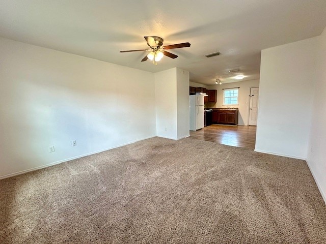 unfurnished living room with carpet and ceiling fan