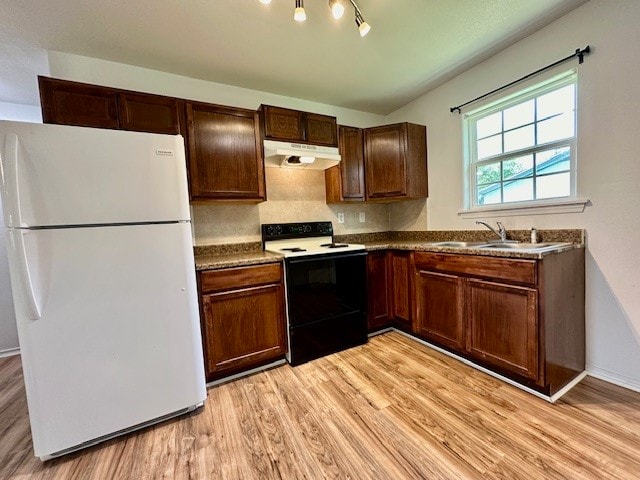 kitchen with white appliances, sink, and light hardwood / wood-style flooring