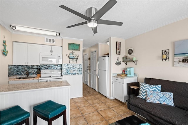 3938 Surfside Blvd Unit 1316, Corpus Christi, TX 78402 - kitchen featuring white appliances, light countertops, a sink, ornamental molding, and decorative backsplash