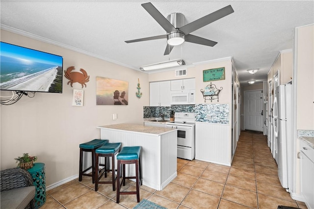 3938 Surfside Blvd Unit 1316, Corpus Christi, TX 78402 - kitchen with white appliances, a kitchen bar, white cabinetry, light countertops, and crown molding