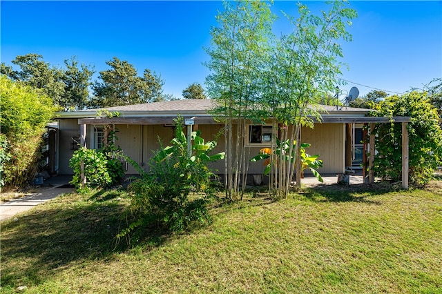 rear view of property featuring a lawn