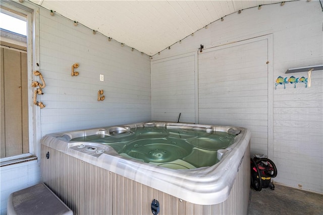 miscellaneous room featuring lofted ceiling, concrete floors, and a jacuzzi