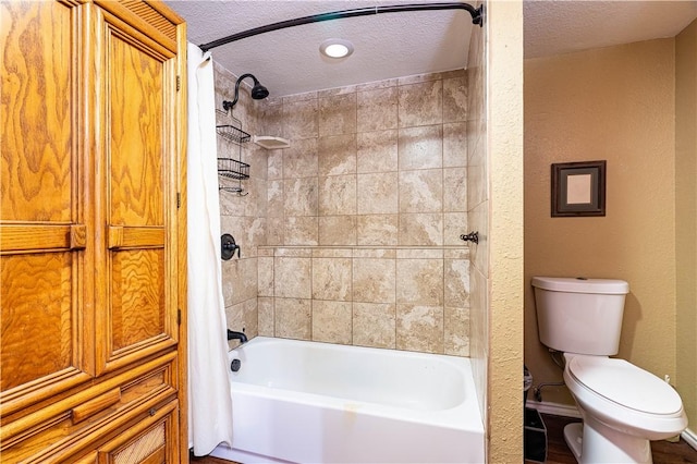 bathroom featuring a textured ceiling, shower / bath combination with curtain, and toilet