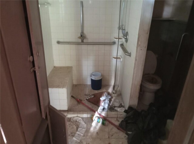 full bathroom featuring toilet and a tile shower