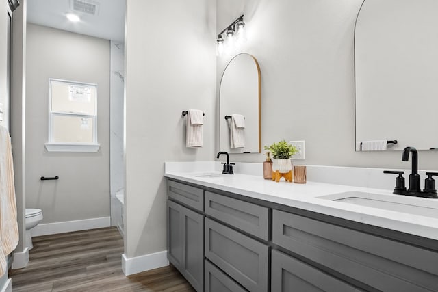 full bathroom featuring vanity, hardwood / wood-style floors, shower / bathtub combination, and toilet