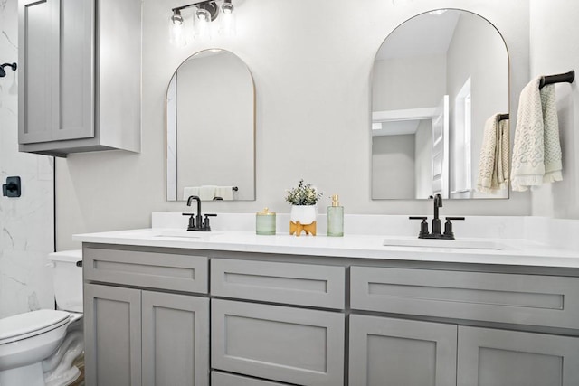 bathroom featuring vanity, walk in shower, and toilet