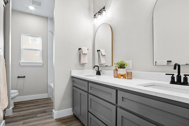 full bathroom with vanity, hardwood / wood-style floors, shower / bathing tub combination, and toilet