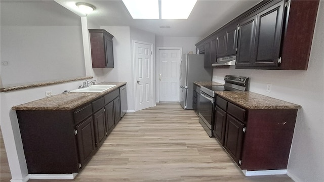 5411 Cypress Cir, Kingsville, TX 78363 - kitchen featuring light wood finished floors, stainless steel appliances, a sink, baseboards, and under cabinet range hood