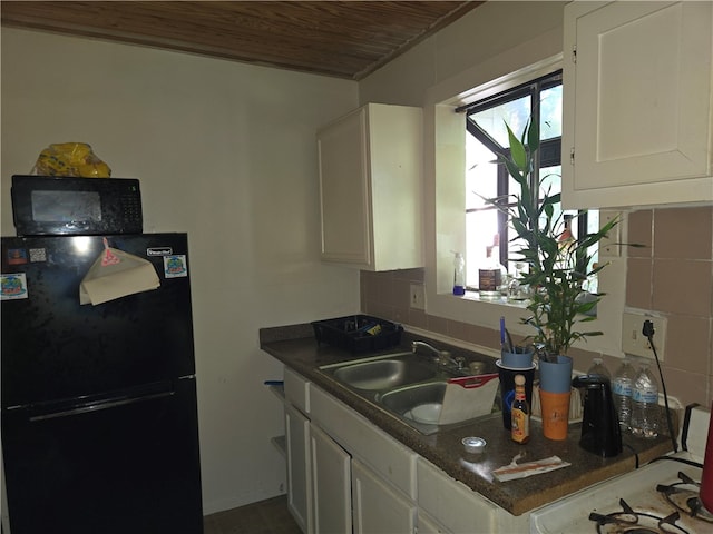 kitchen with black appliances, tasteful backsplash, sink, white cabinets, and wooden ceiling