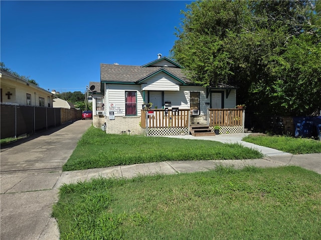 bungalow-style home with a wooden deck and a front yard