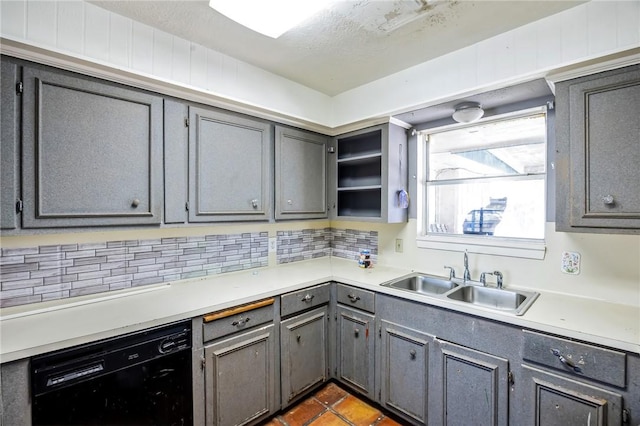 kitchen featuring gray cabinets, light countertops, a sink, and dishwasher